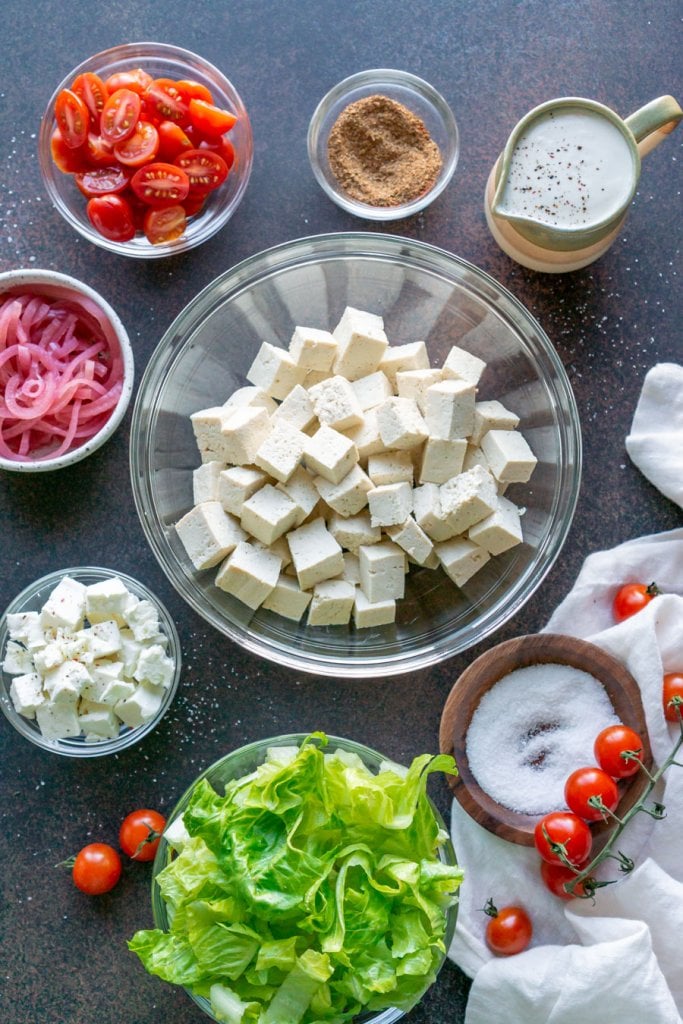 ingredients in small bowls, tofu, romaine, pickled onions, feta cheese, tomatoes