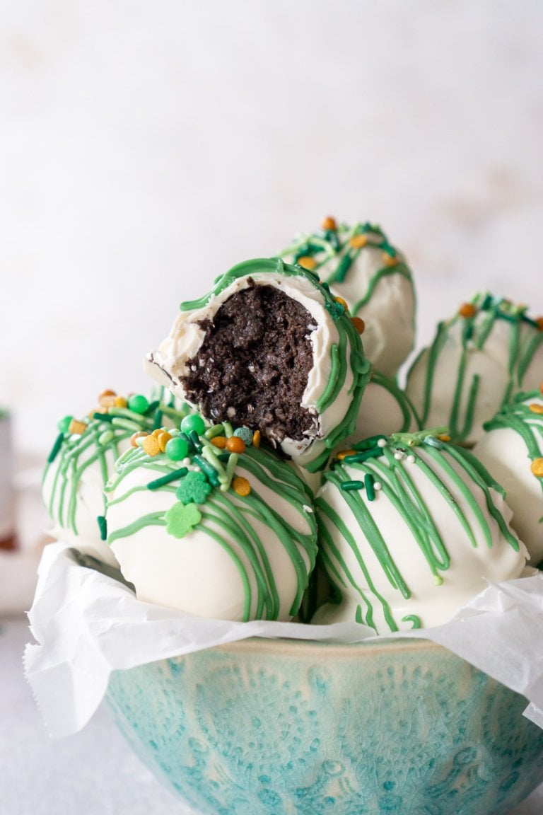 oreo cookie balls in a blue bowl with a bite taken out of one