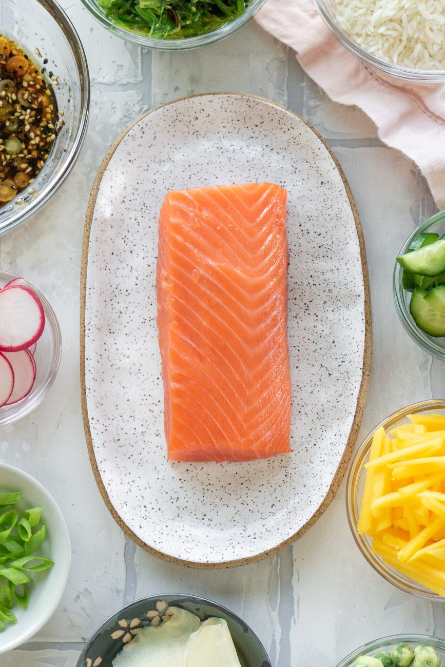 Sushi grade salmon on a white plate.