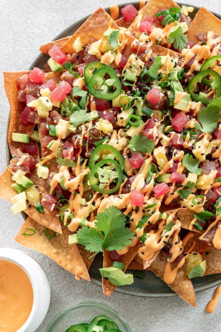 tuna poke nachos on a plate with spicy mayo on the side