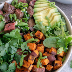 steak bowl with sweet potatoes, avocado, steak, and lettuce