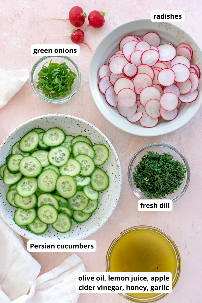 sliced cucumbers, radishes, dill, green onions, and olive oil in bowls.