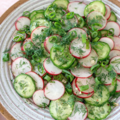 Cucumber radish salad in a white serving bowl.