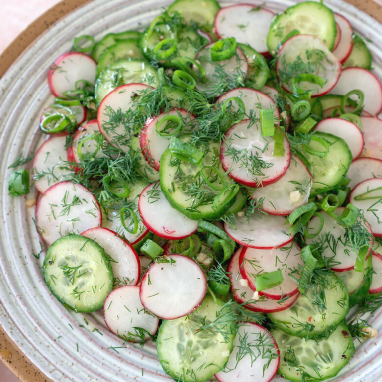 Cucumber radish salad in a white serving bowl.