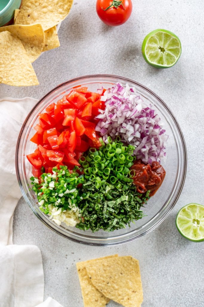 ingredients for chunky salsa in a glass mixing bowl