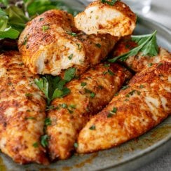 oven baked chicken tenders on a plate and a bite on a fork