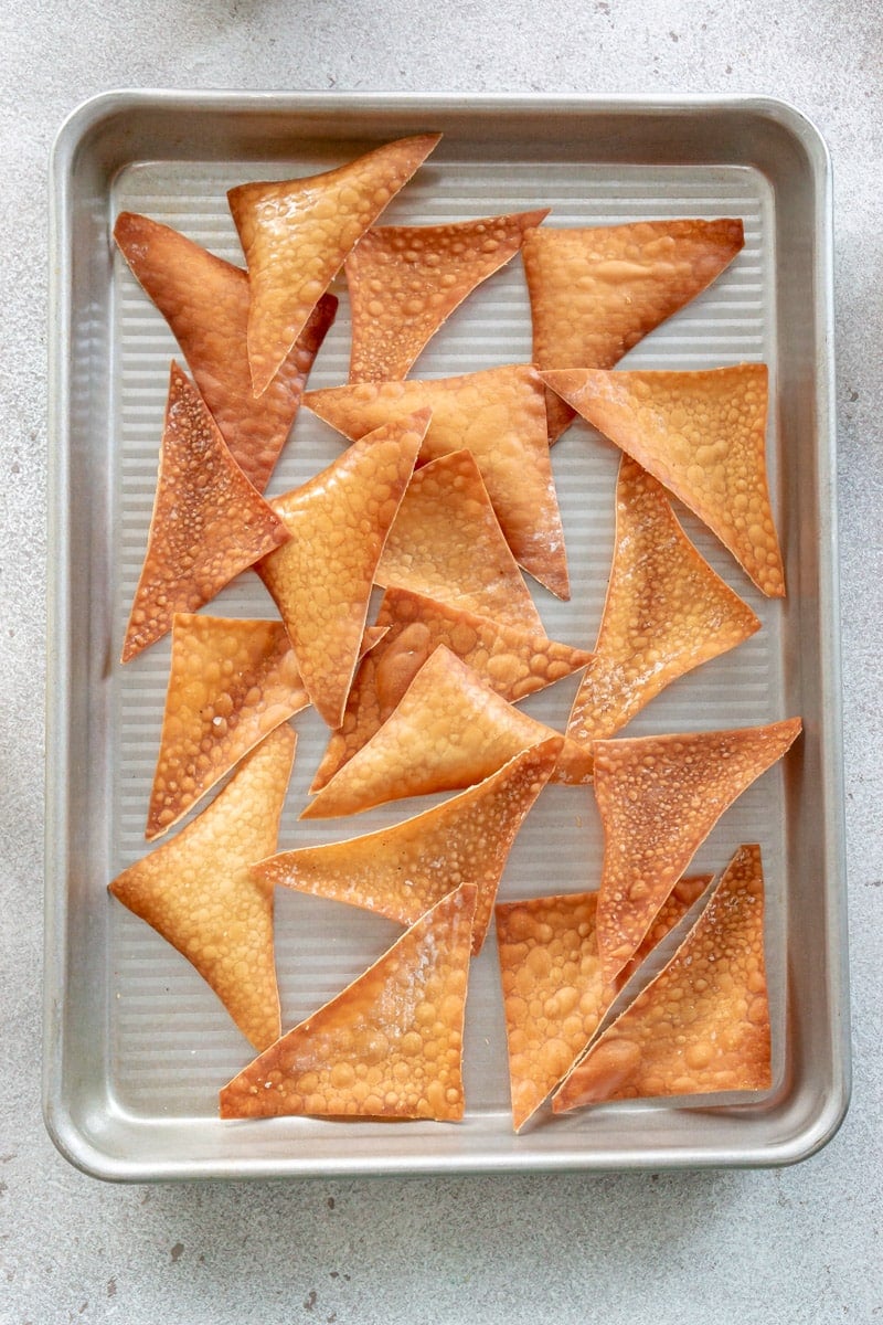 Baked wonton chips on a sheet pan.