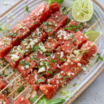 watermelon tajin skewers on a serving plate with lime