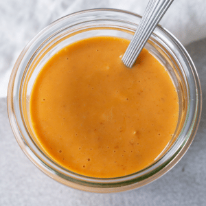 bang bang sauce in a glass jar with a spoon