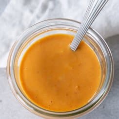 bang bang sauce in a glass jar with a spoon