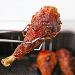 tongs holding an air fryer turkey leg