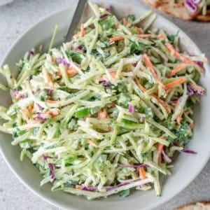 fish taco slaw in a white bowl with a silver spoon.