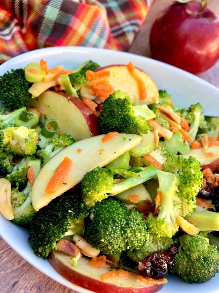 Broccoli Crunch Salad with Apples & Almonds and carrots in a white bowl.