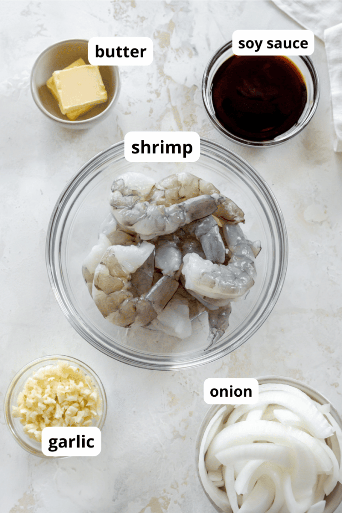 raw shrimp, butter, soy sauce, garlic, and onion in small ingredient bowls