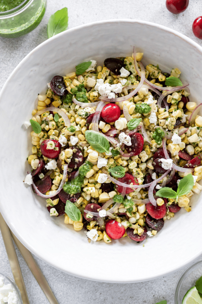 overview of summer corn salad in white bowl with basil garnish