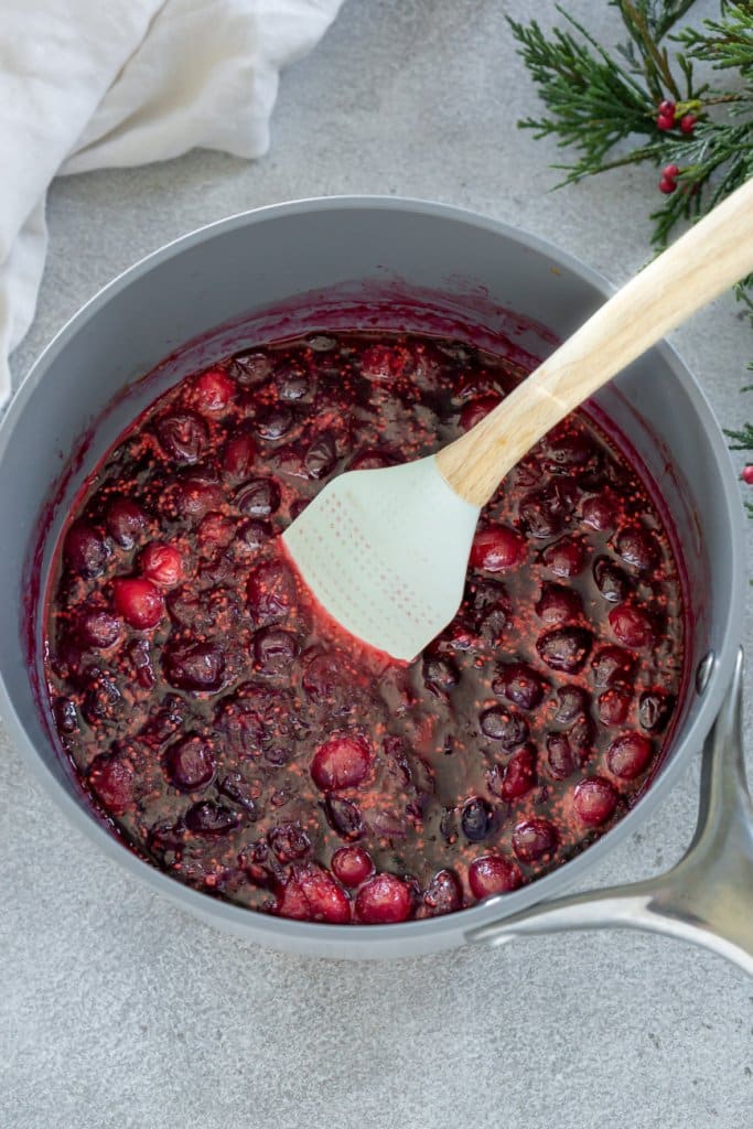 cranberry sauce in a sauce pan with a spatula