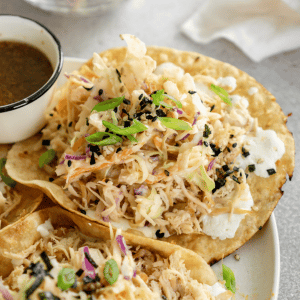 trader joes soyaki chicken taco on a plate with soyaki sauce in a small cup and a white napkin