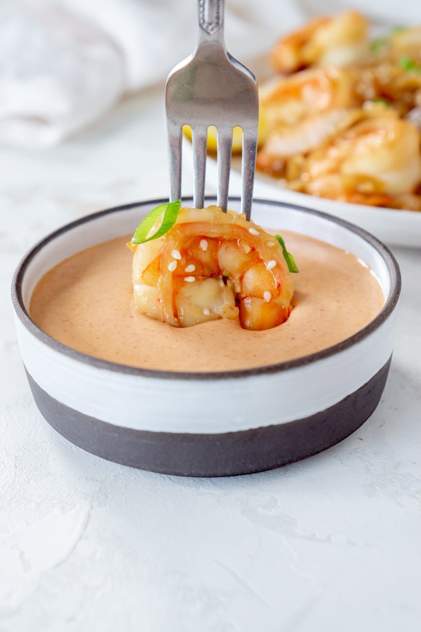 fork dipping shrimp in yum yum sauce.