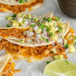 Baked chicken taco on parchment paper with a lime.