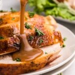 pouring gravy over sliced roasted turkey