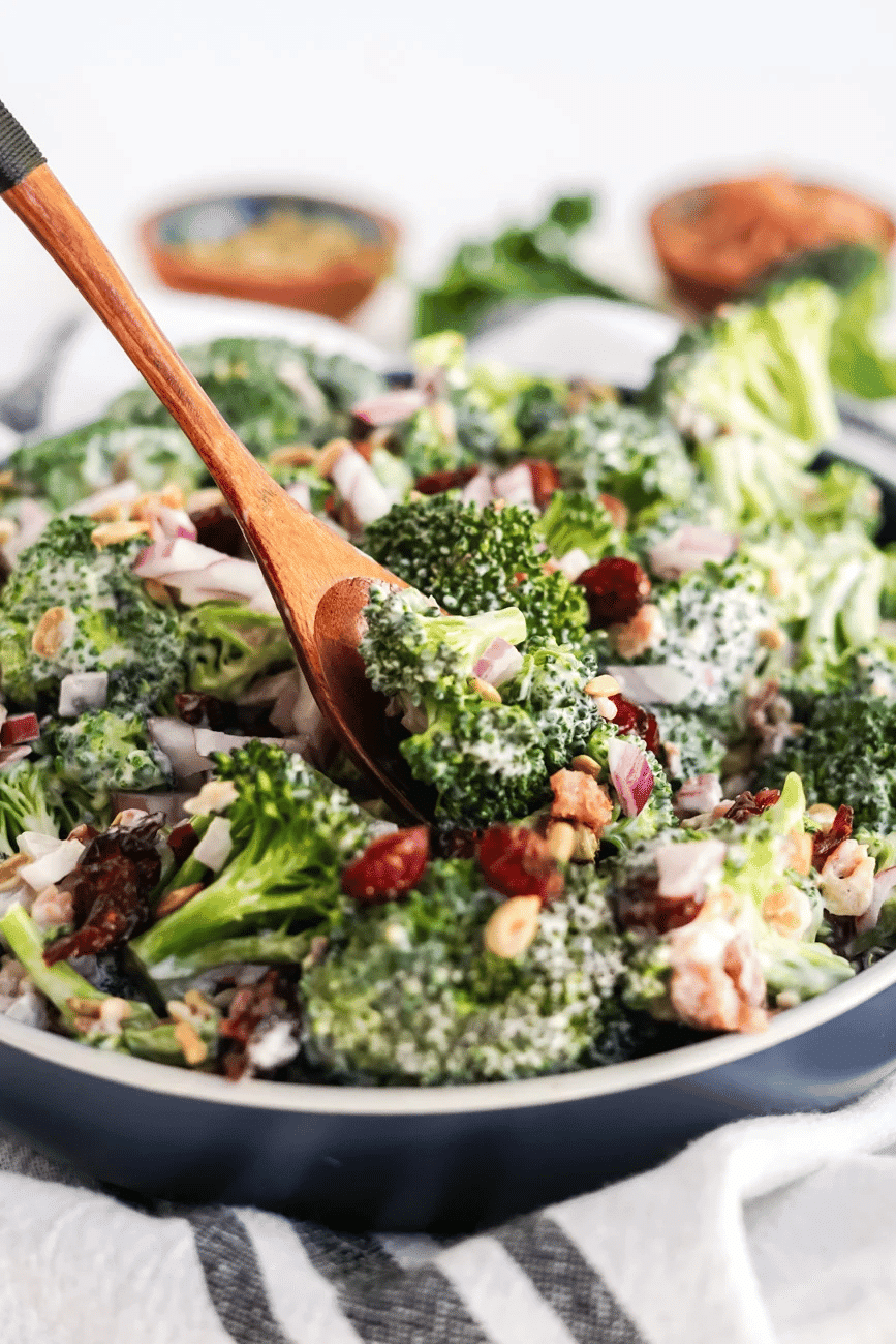 Broccoli salad on wooden spoon.