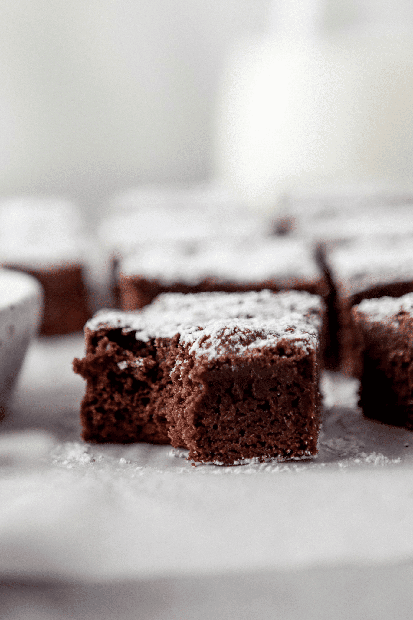 Close up of chocolate brownie with powdered sugar on top.