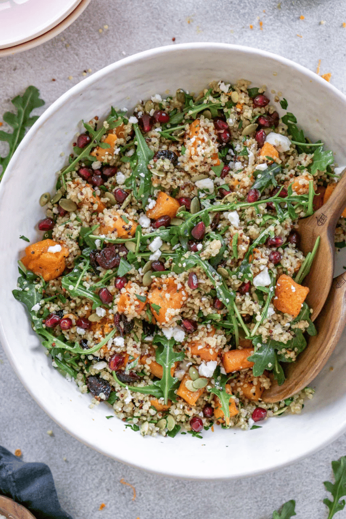 white bowl of quinoa salad with butternut squash and cranberries