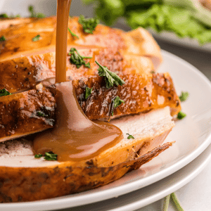 pouring gravy over sliced turkey