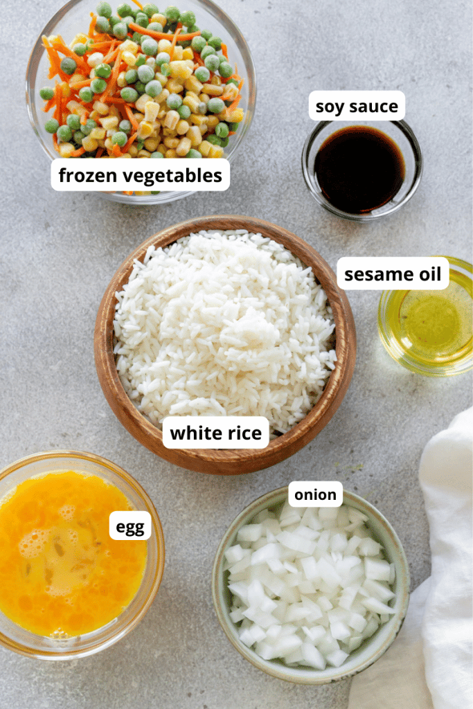 rice, vegetables, egg, onion, and oil in small individual bowls