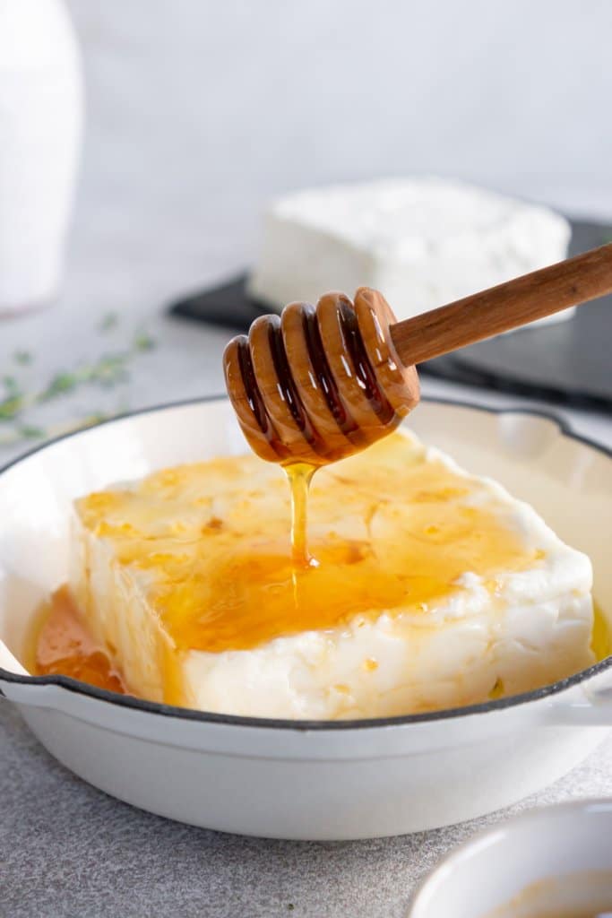 drizzling hot honey on a block of feta cheese