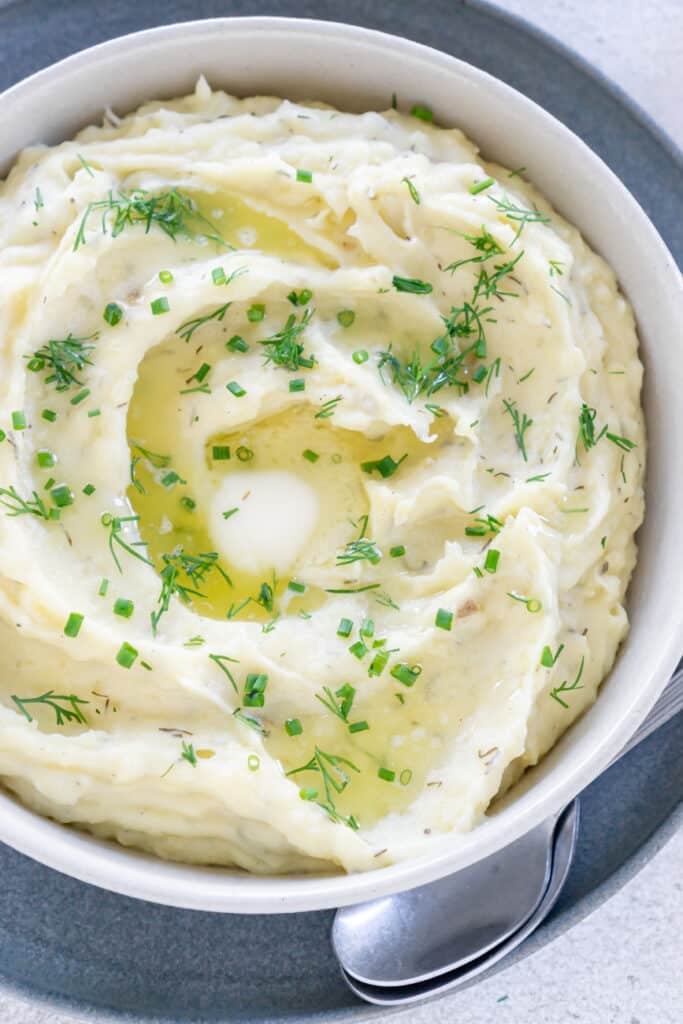 Mashed potatoes in a bowl and topped with chives.