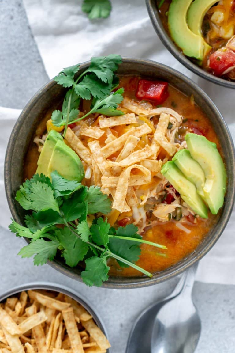 chick fil a chicken tortilla soup in a bowl with avocado, tortillas, and cilantro