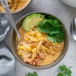 chicken taco soup in a bowl with a spoon, another bowl of soup to the side
