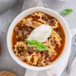 three bowls of one pot lasagna soup with two spoons on the side