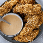 pretzel crusted chicken tenders on a plate with honey mustard sauce