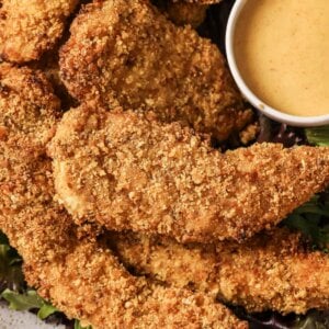 close up photo of pretzel crusted chicken with honey mustard dipping sauce.