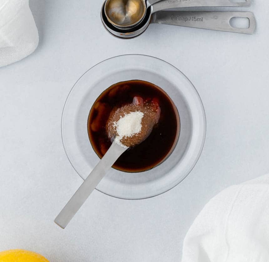 Ingredients for Katsu sauce in a clear bowl with a spoon.