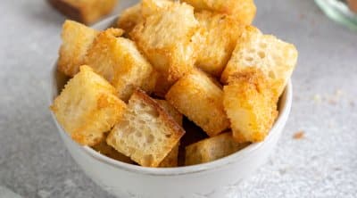 air fryer croutons in a small bowl with a green linen to the side