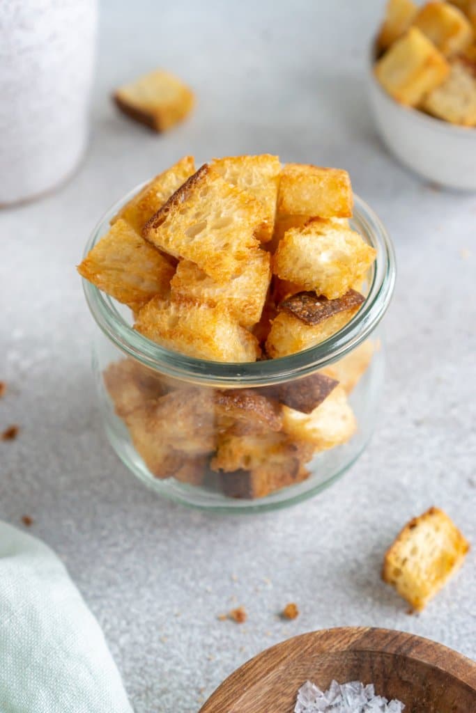 close up of air fryer croutons in a glass jar.