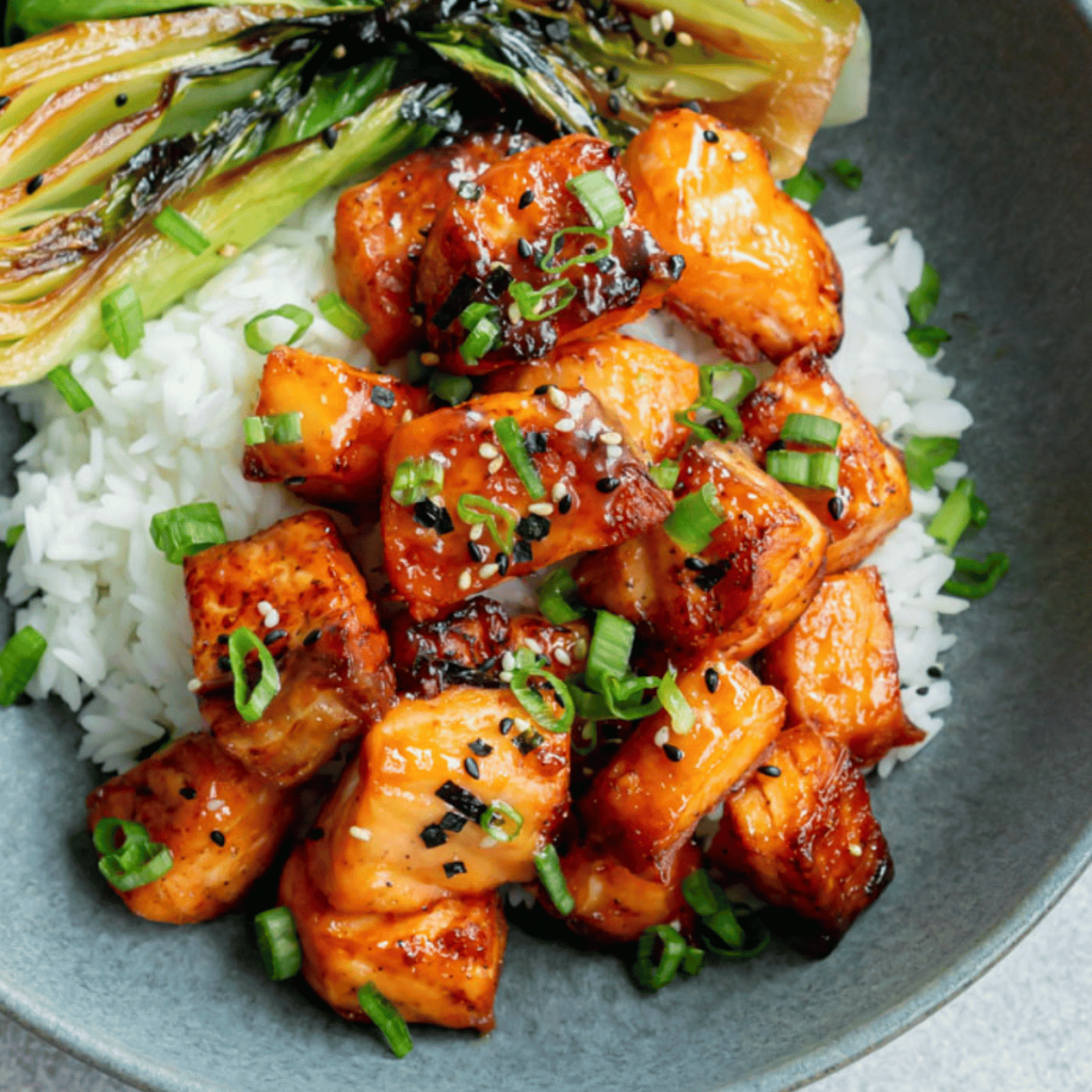 Miso air fryer salmon bites in a blue bowl with bok choy and rice.