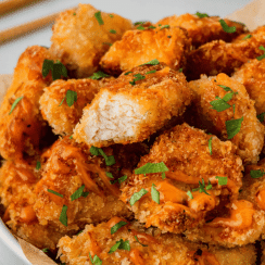 Bang bang chicken on a plate, one piece with a bite taken.