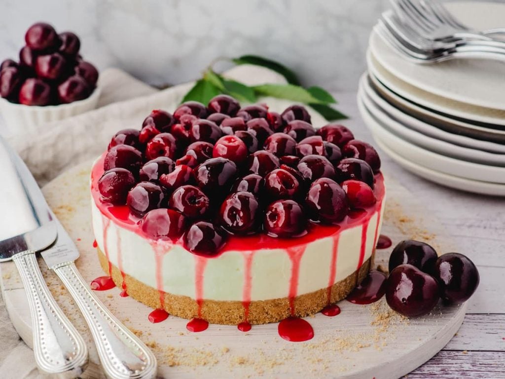 overhead view of cherry cheesecake with cherries on top and juice running down the side