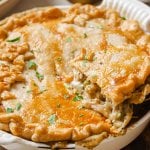 thanksgiving leftover pot pie in a white pie dish and lifting a piece out