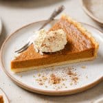 a piece of sweet potato pie on a plate with whipped cream on top and a fork