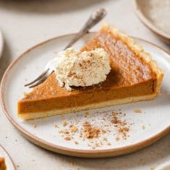 a piece of sweet potato pie on a plate with whipped cream on top and a fork