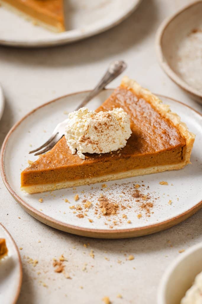 a piece of sweet potato pie on a plate with whipped cream on top and a fork