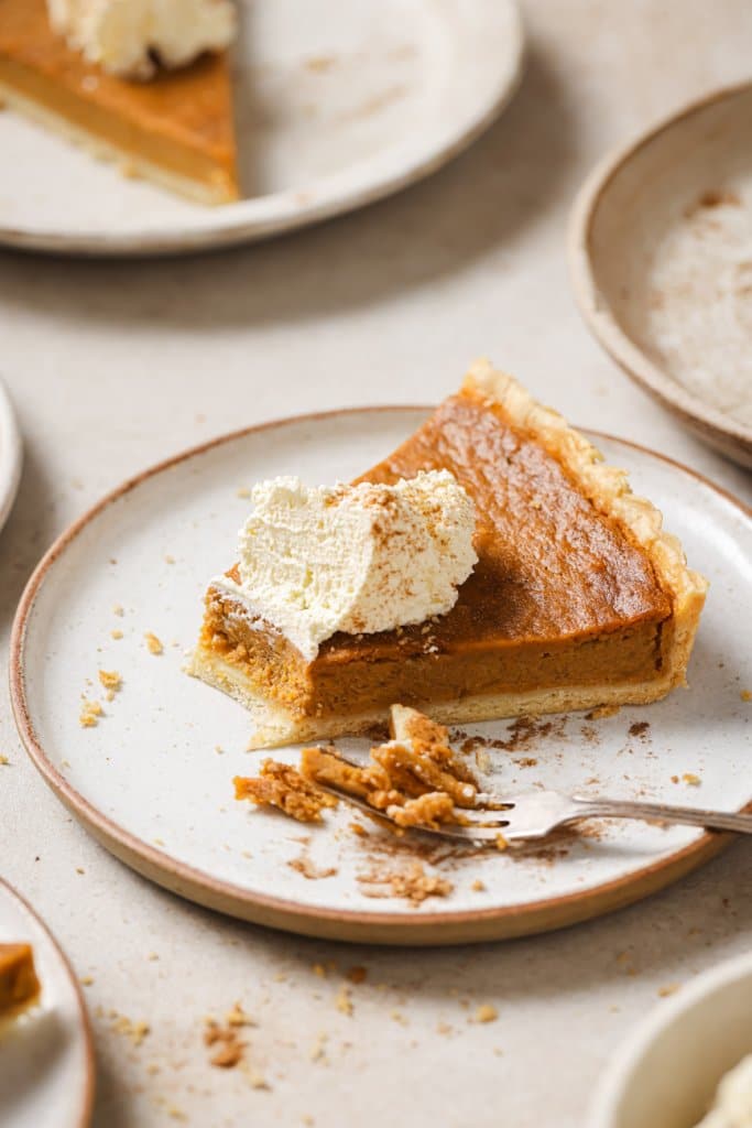 a slice of sweet potato pie on a plate with a bite taken