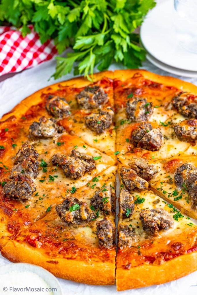 close up of a cheesy meatball pizza