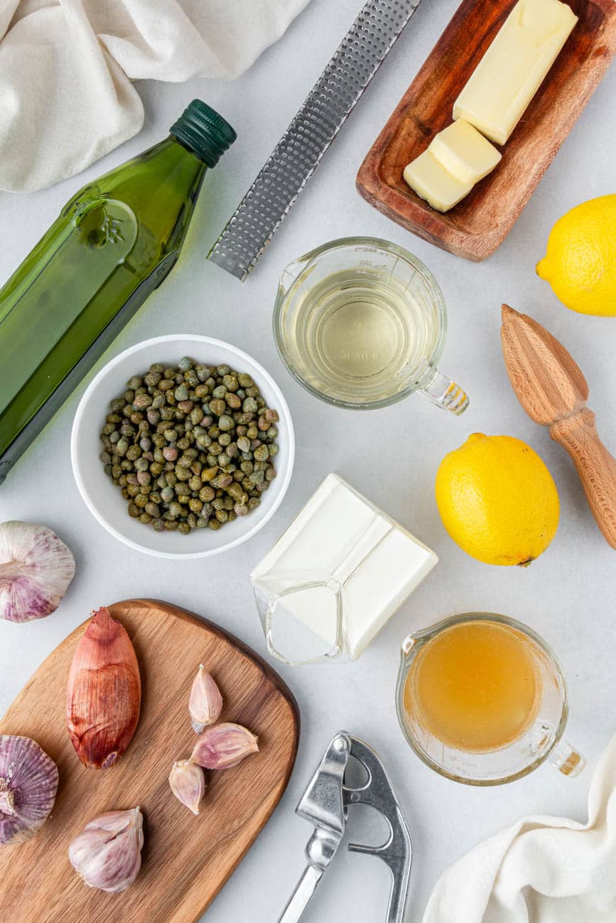 Olive oil, lemons, butter, capers, shallots, and cream in small ingredient bowls.