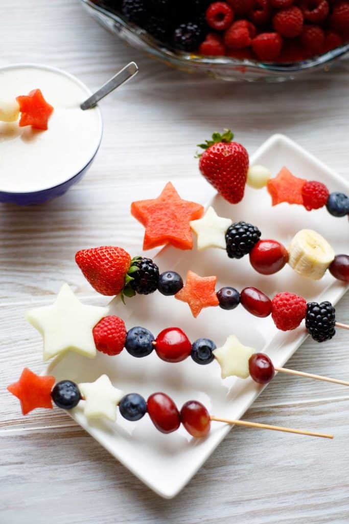 red white and blue fruit kabobs on white plate